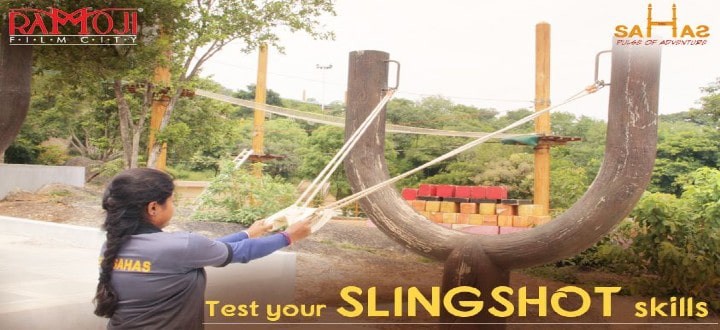 Players aiming a giant catapult at targets in the Happy Hits game at Sahas
